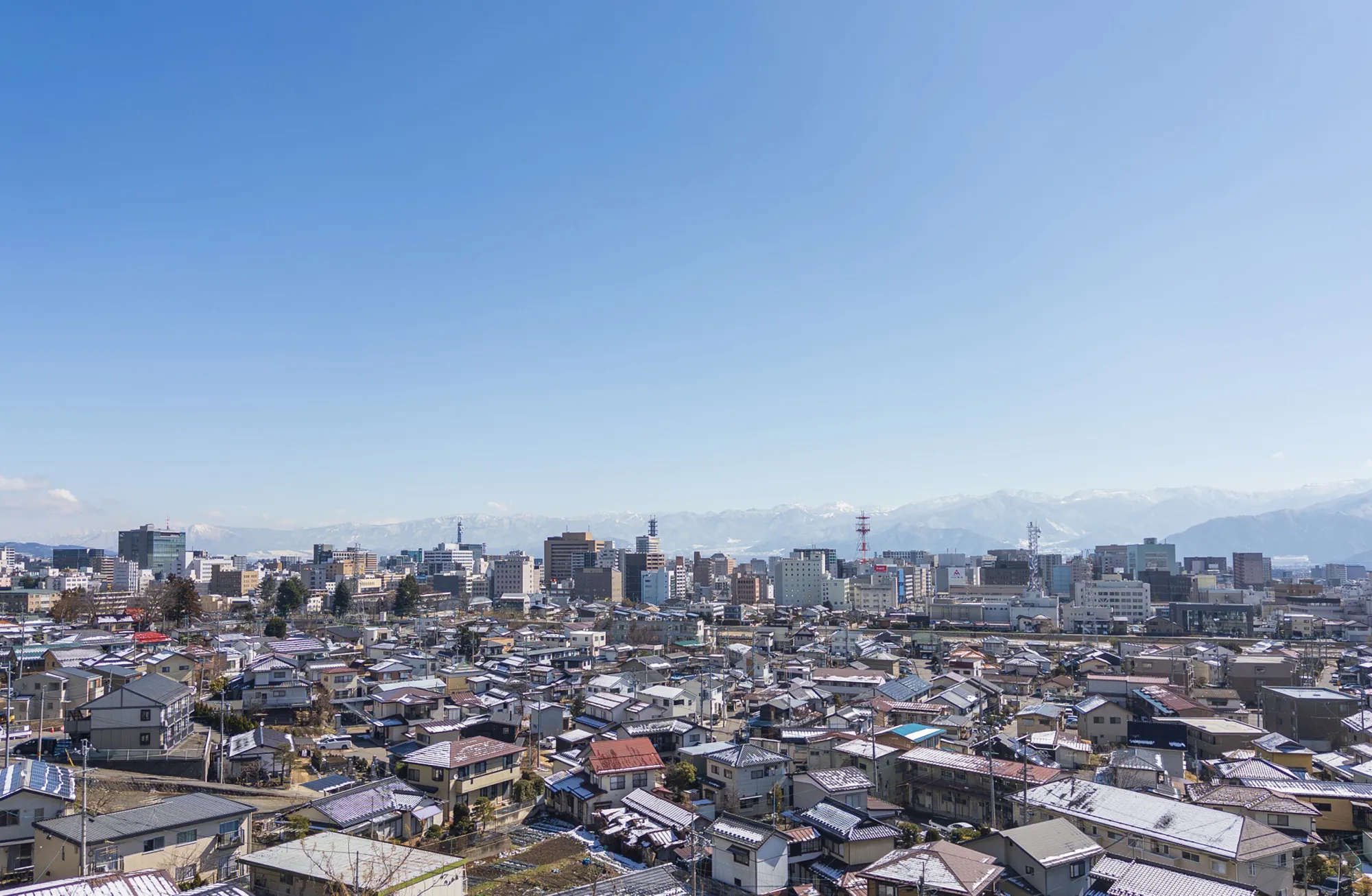 長野県の街並み。青空と山々が広がる地域の風景。